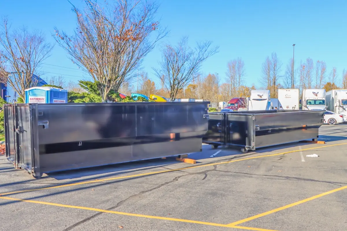 Professional dumpster rental service with roll-off container on residential driveway in Kings Grant